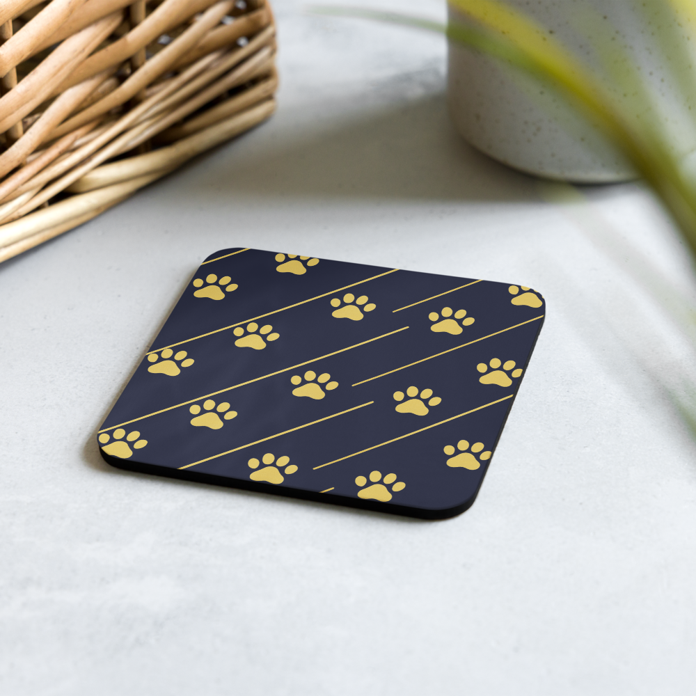Coaster with yellow paw print pattern on a blue background, placed on a light surface.