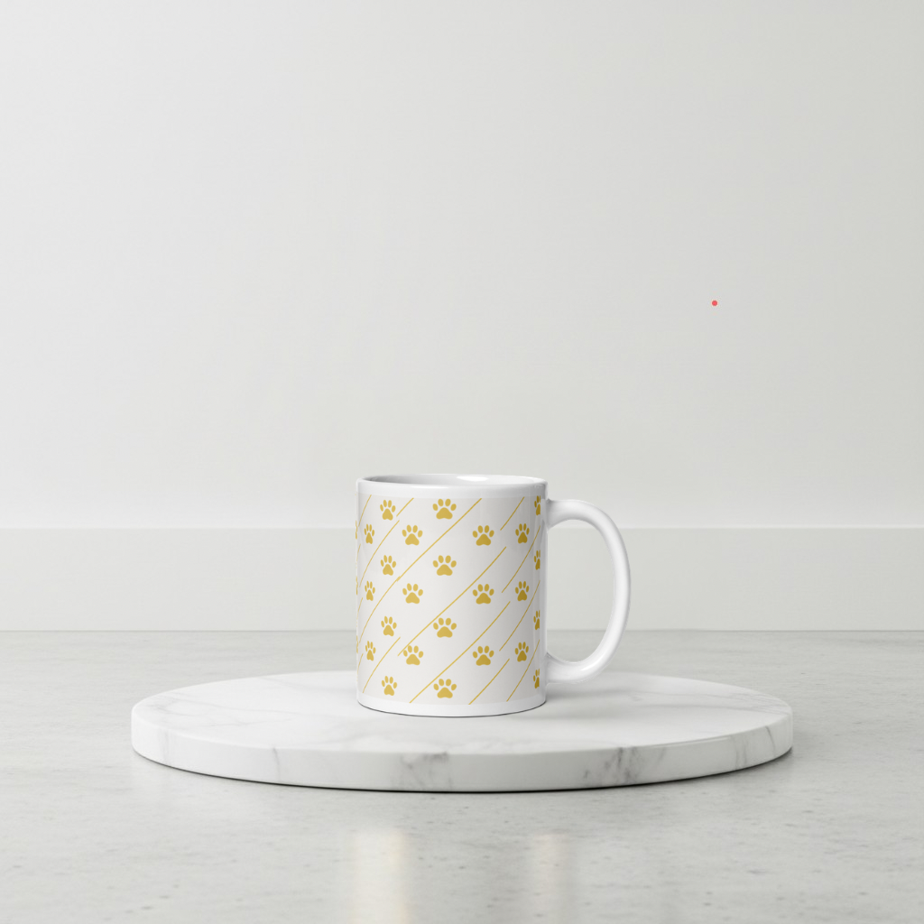 Ivory Whisper mug with gold paw print pattern on a marble coaster with a light gray background