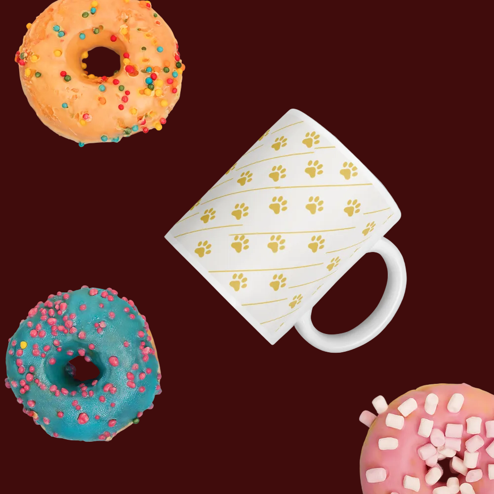 Ivory Whisper mug with paw prints, surrounded by colorful donuts on a dark background