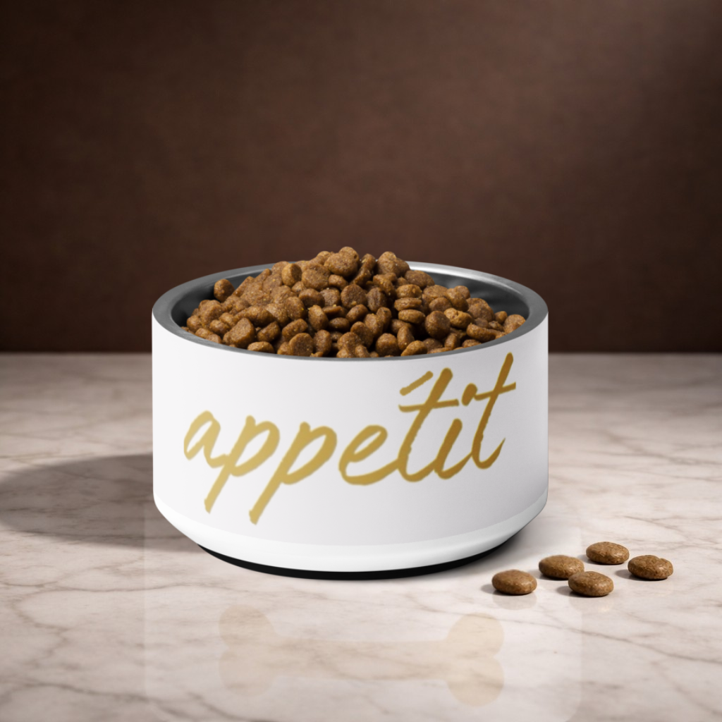 White bowl with 'appétit' text filled with dog food on a marble surface.