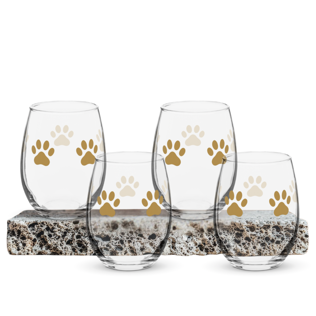 Set of four clear glasses with gold paw prints on a white background