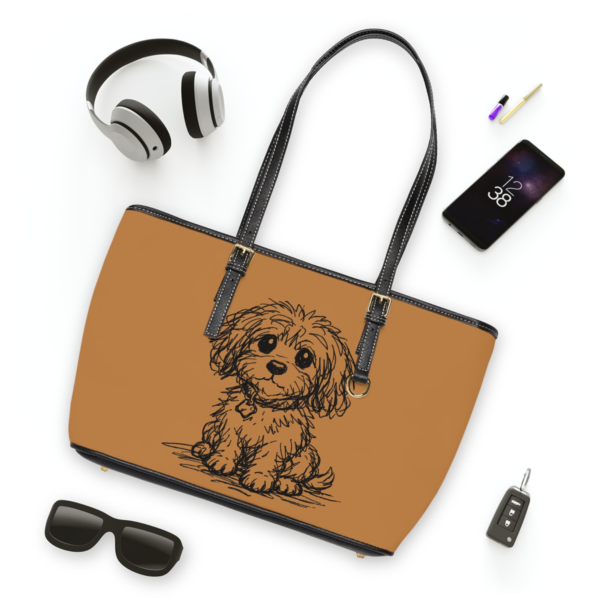 Brown tote bag with a dog illustration, surrounded by headphones, phone, sunglasses, and car key on a white background.