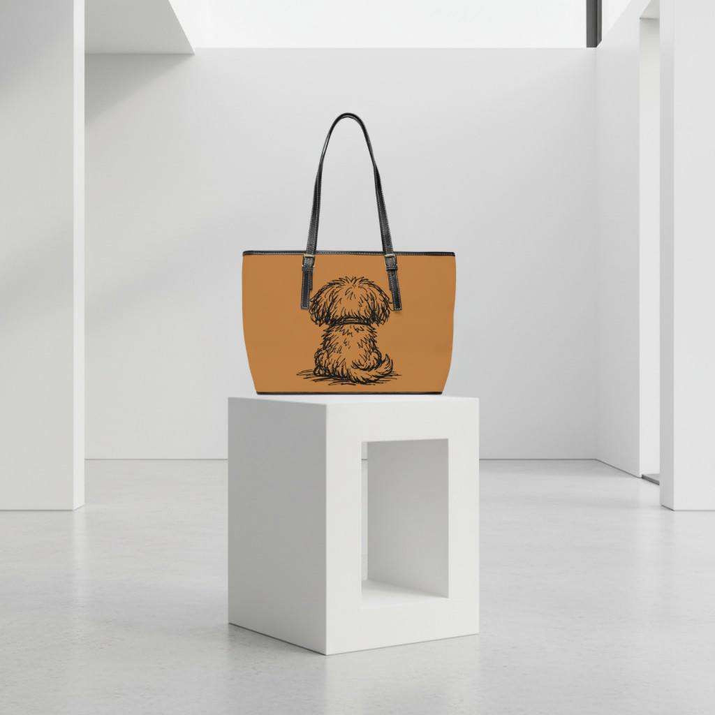 Tan handbag with a dog illustration on a white pedestal against a white background