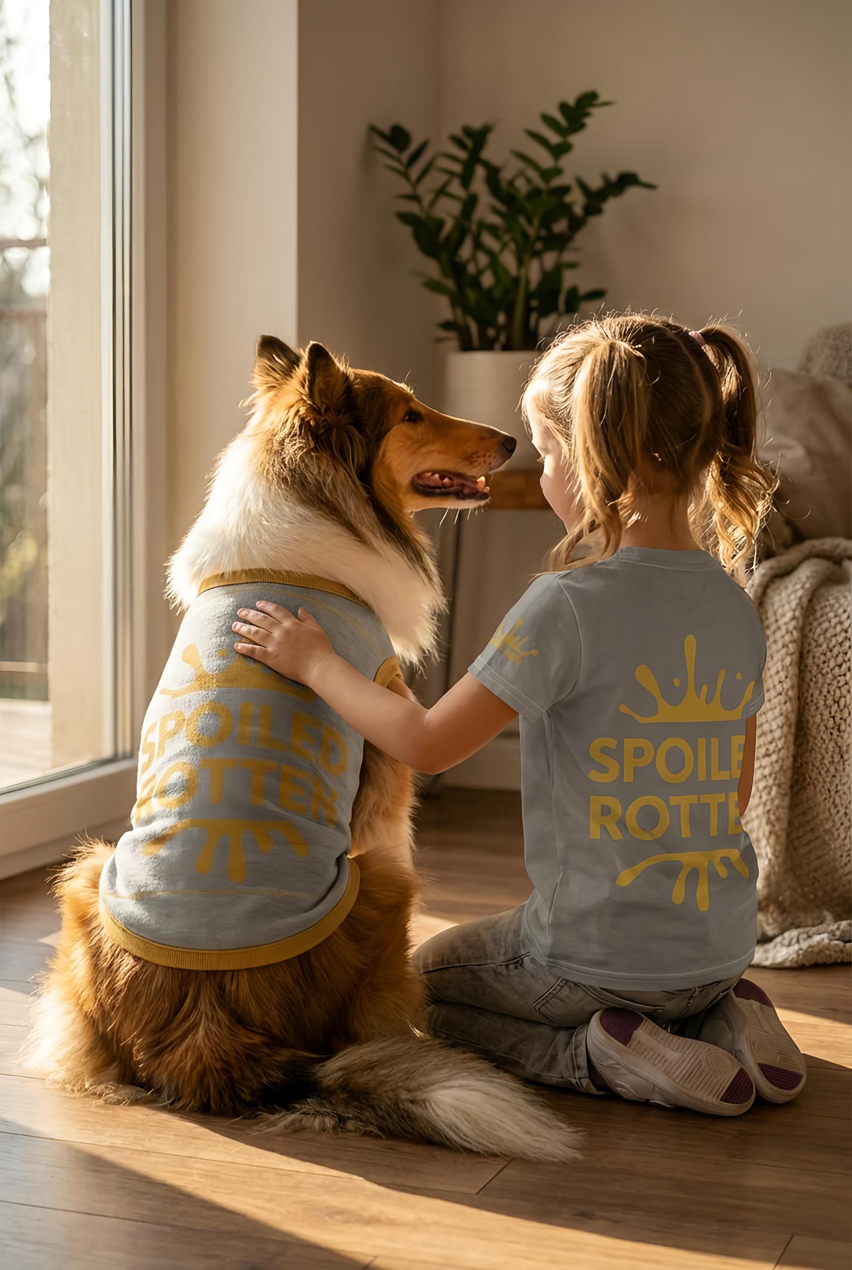 Dog and child wearing matching 'Spoil Rotties' shirts in a cozy room.