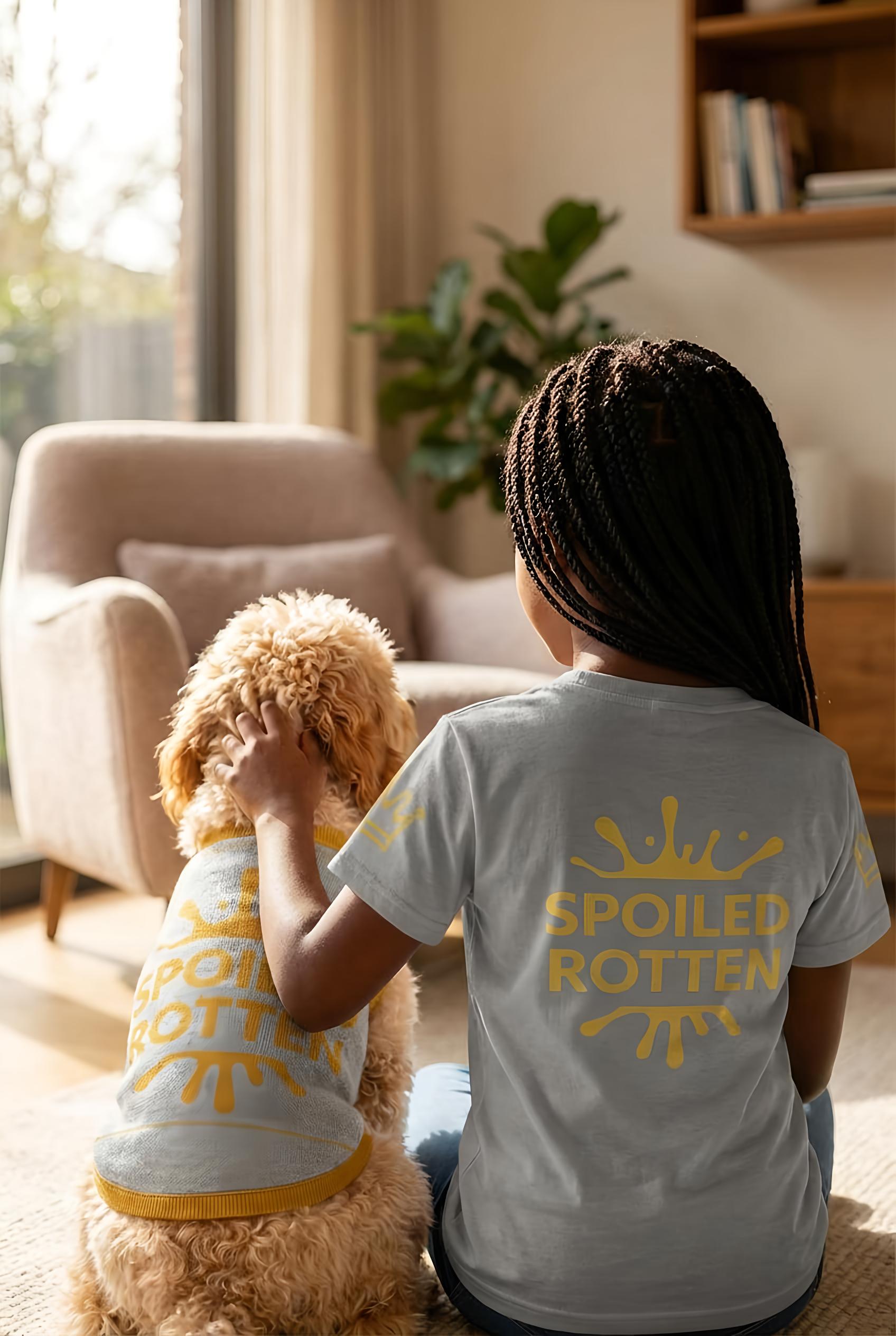 Two children sitting on a couch with matching 'SPOILED ROTTEN' shirts in a cozy living room.