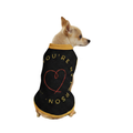 Dog wearing a black sweater with yellow text and a red heart on a white background