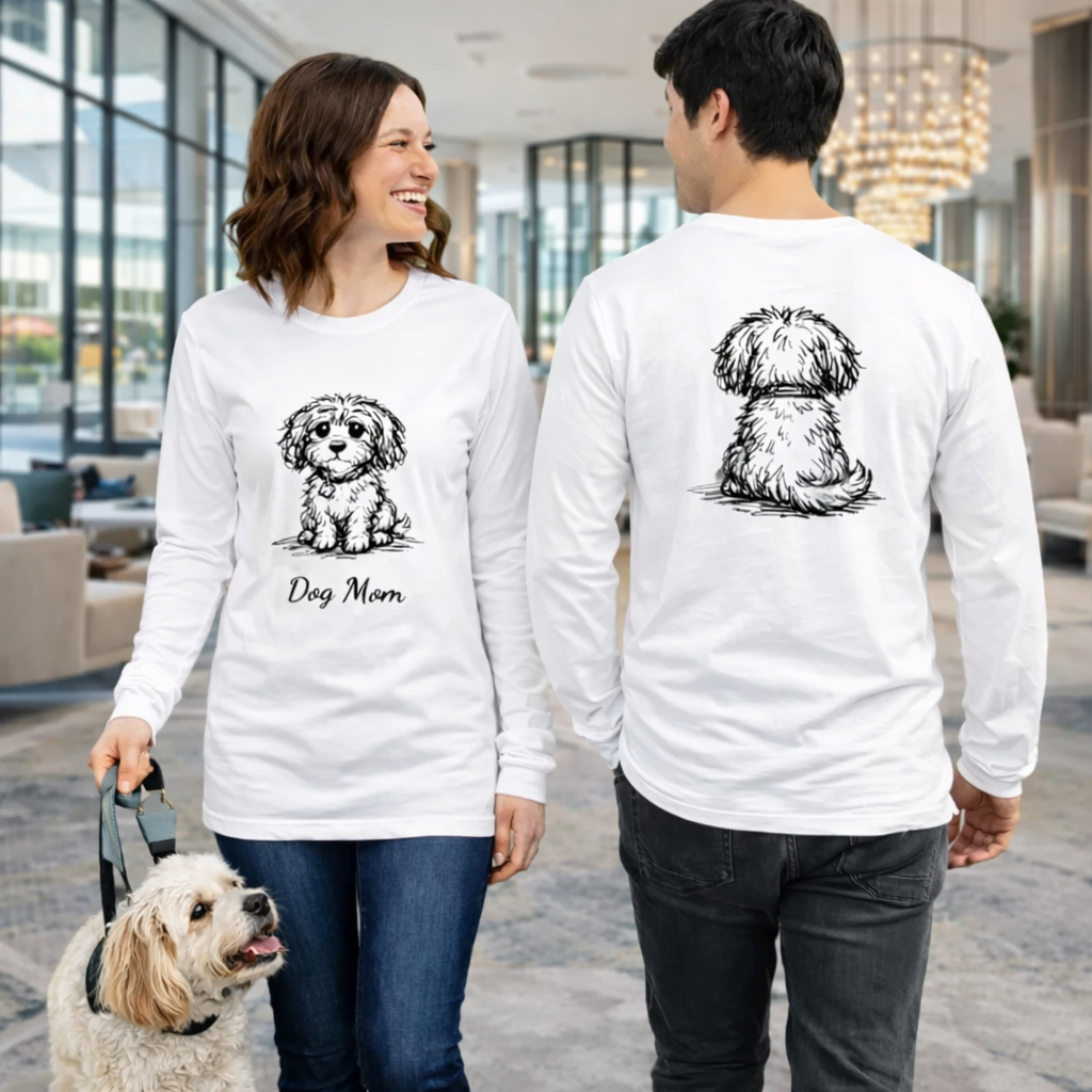 Two people wearing matching white long-sleeve shirts with dog illustrations and text, walking a dog indoors.
