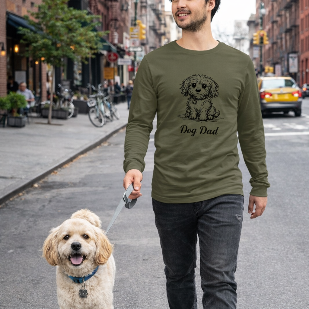 Man walking a dog on a city street wearing a long-sleeve shirt with 'Dog Dad' text.