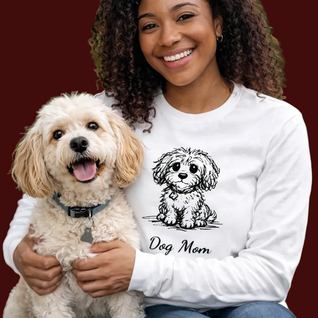 Woman wearing a white sweatshirt with a dog illustration and 'Dog Mom' text, holding a small white dog.