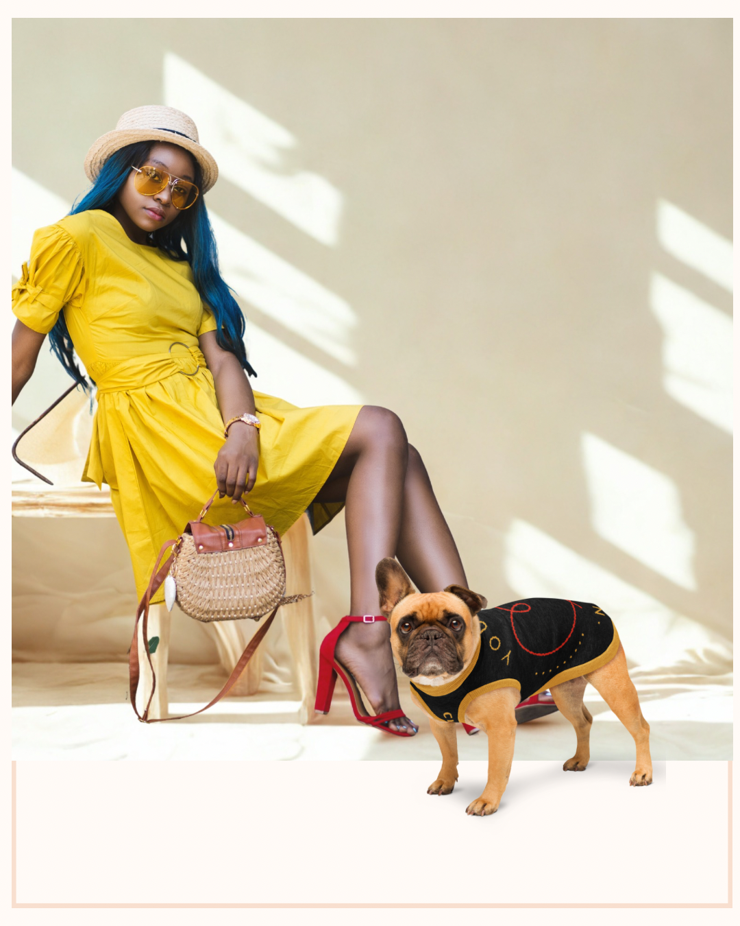 Woman in yellow dress with blue hair sitting on a bench next to a small dog wearing a black outfit.