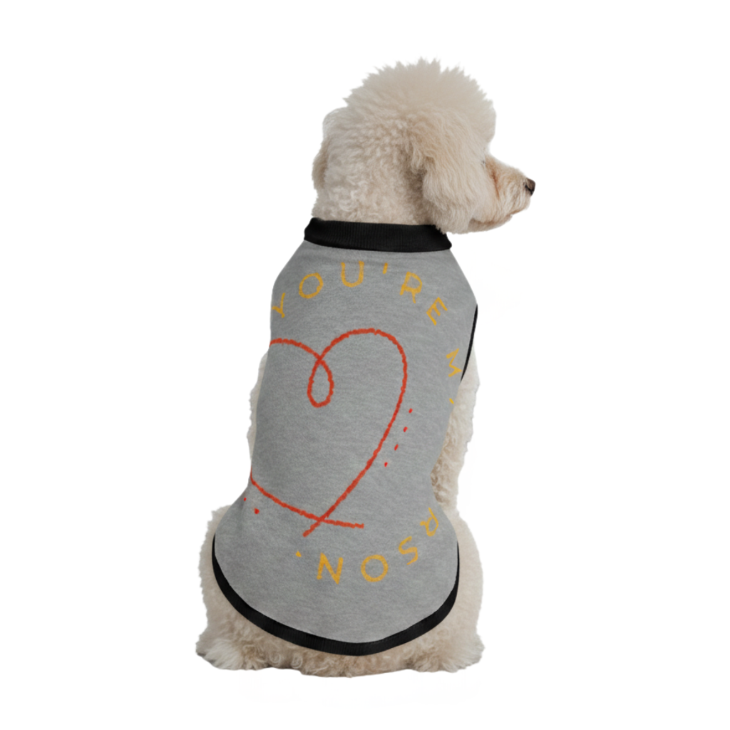 Dog wearing a gray t-shirt with text and a heart design on a white background