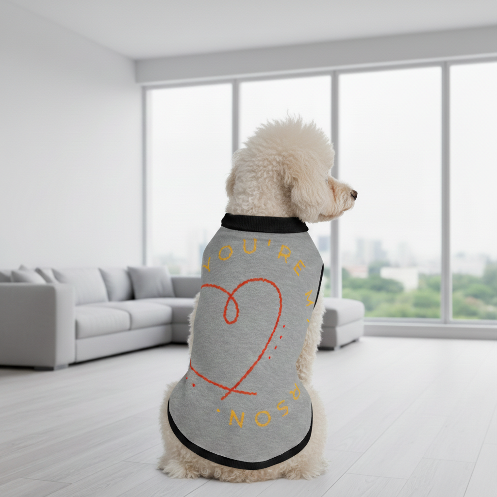 Dog wearing a sweater with text and a heart design in a modern living room.