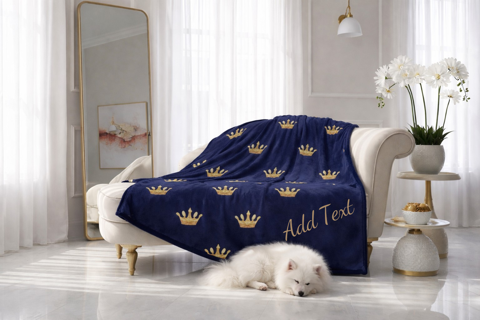 Navy blue blanket with gold crowns and 'Add Text' on a white sofa in a bright room.